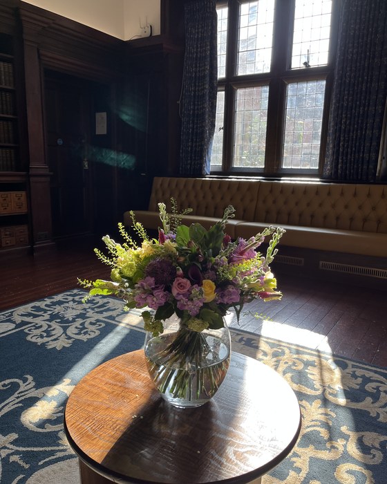 Seasonal arrangement on a table in a panelled room