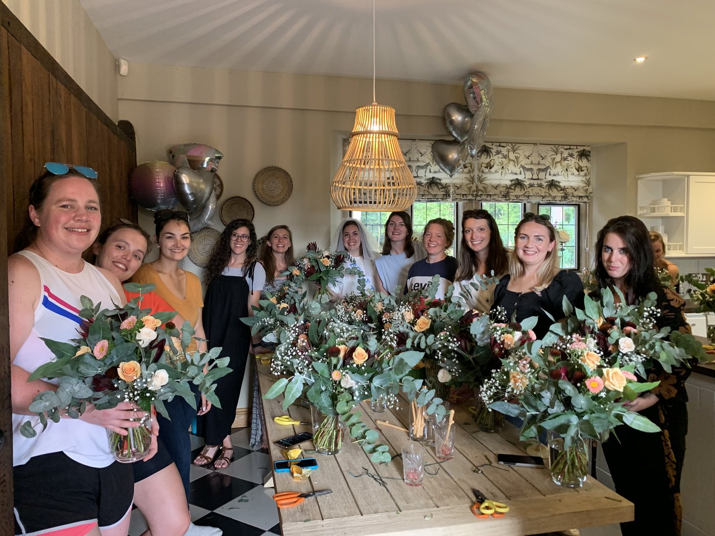 A hen party group with the vase arrangements they made at a Gin House Flowers workshop