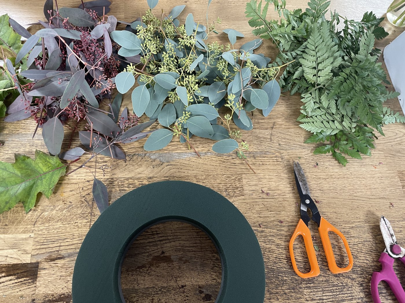 Foliage, a wreath ring and scissors laid out for a class