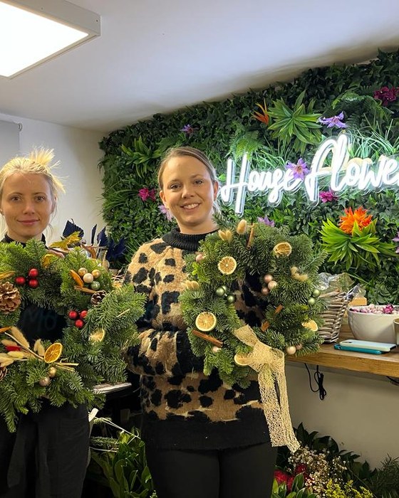 Two guests with their finished Christmas wreaths