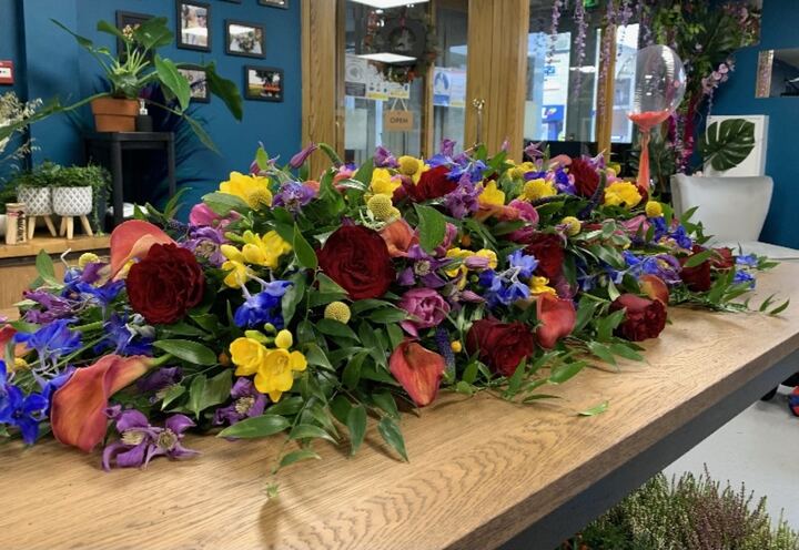 Coffin spray of red roses and yellow flowers