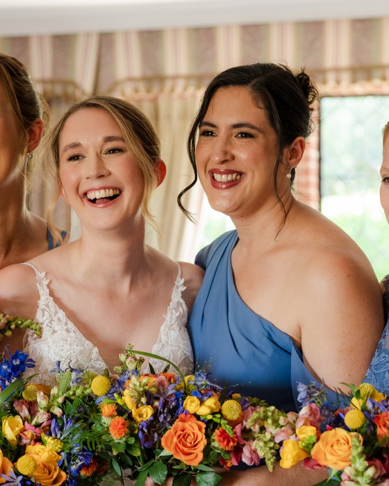 Bridesmaids laughing with colourful bouquets